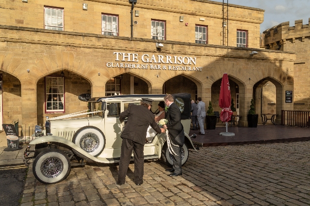 Bride getting out of car in front of Garrison Hotel Sheffield