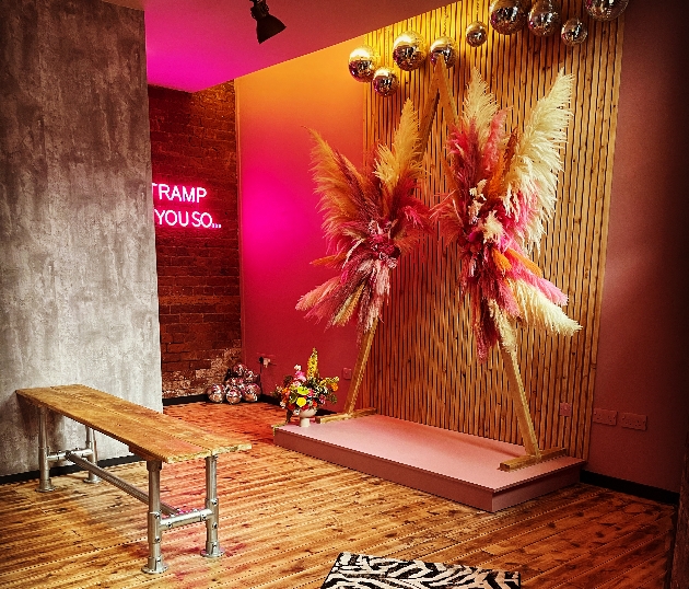 Steel City Chapel ceremony space with pink neon and pampas grass triangular arch