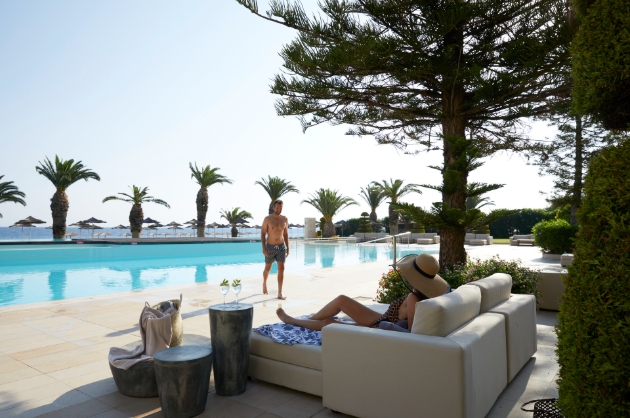 Woman on sun lounger and man walking towards her 